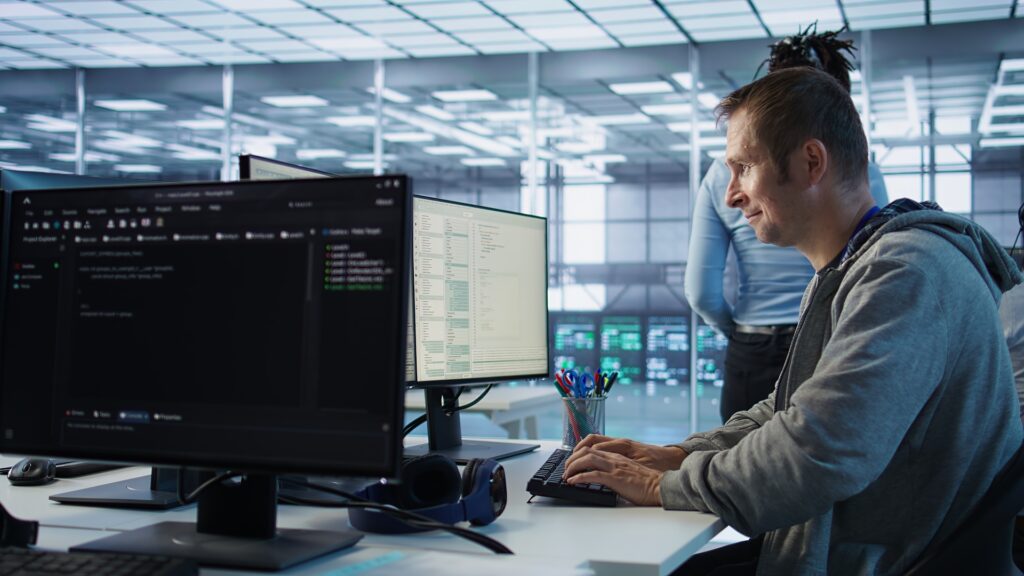 IT technician monitors server performance and energy use in data center.