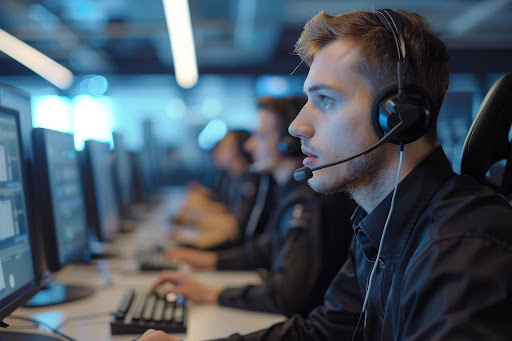 a man wearing a headset looking at a computer